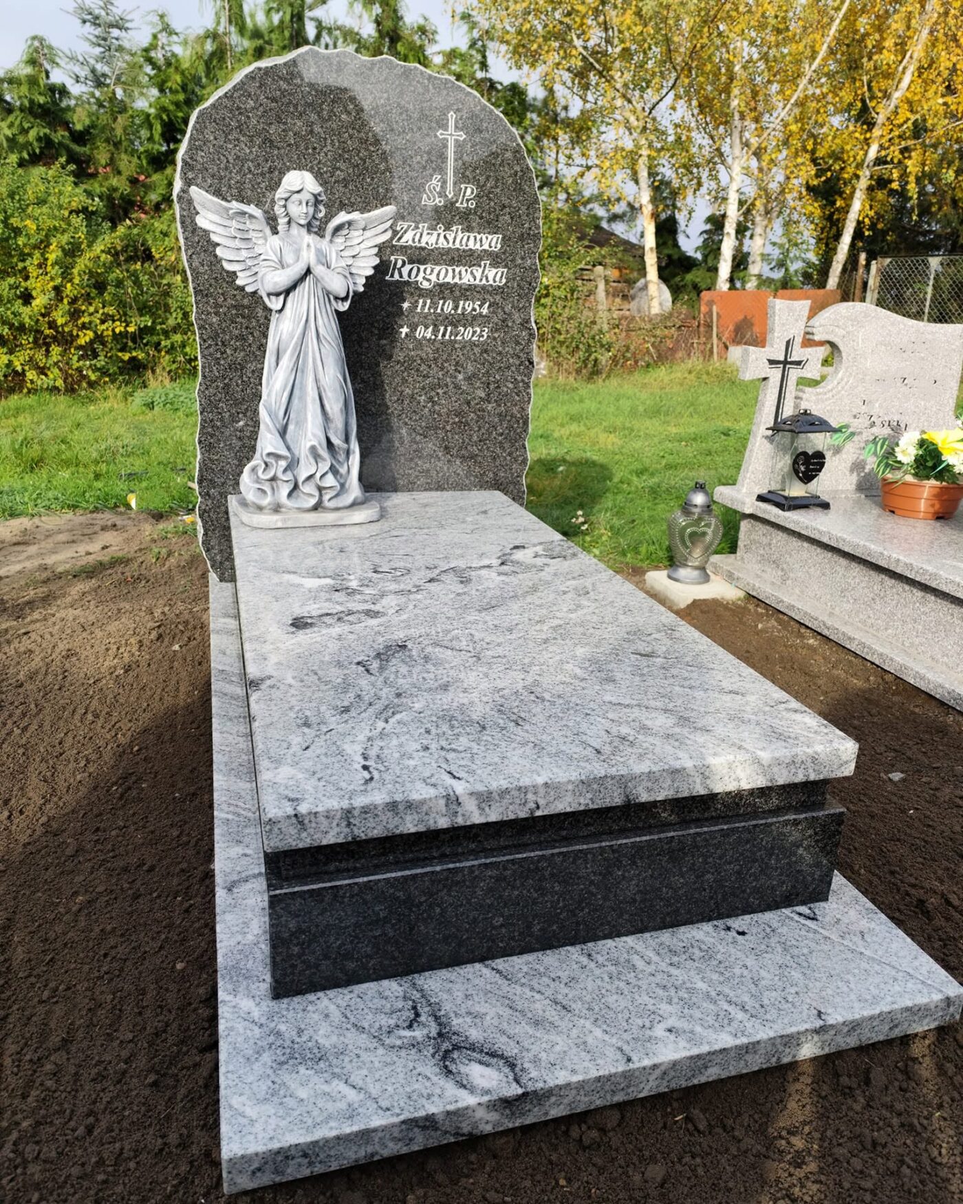 Pomnik pojedynczy z granitu Viscont White z ciemną stelą o naturalnej krawędzi i rzeźbą anioła